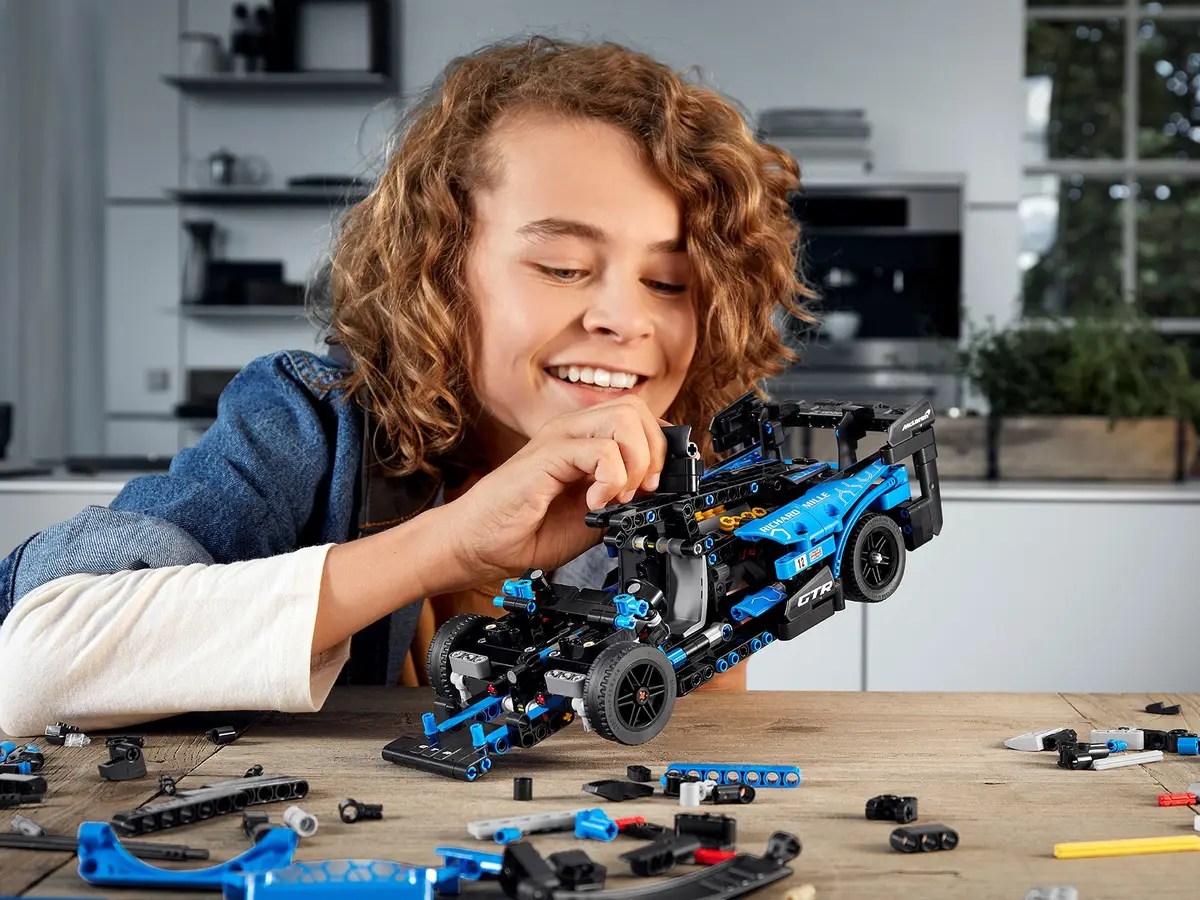 Boy building blue race car from kit